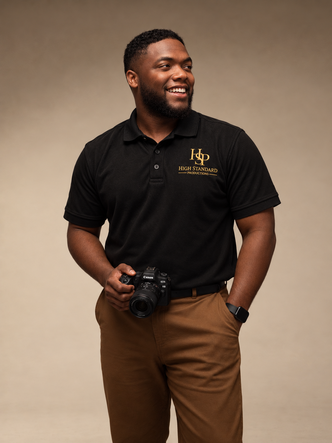 Devonnte Moody smiling in a High Standard Productions polo with a camera at his waist
